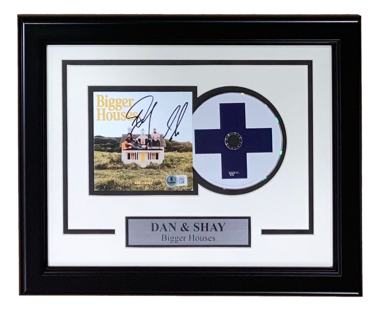 Sports Integrity’s Dan & Shay Signed Framed Bigger Houses CD Insert BAS features a signed album display, CD with blue cross design, and plaque labeled DAN & SHAY Bigger Houses.
