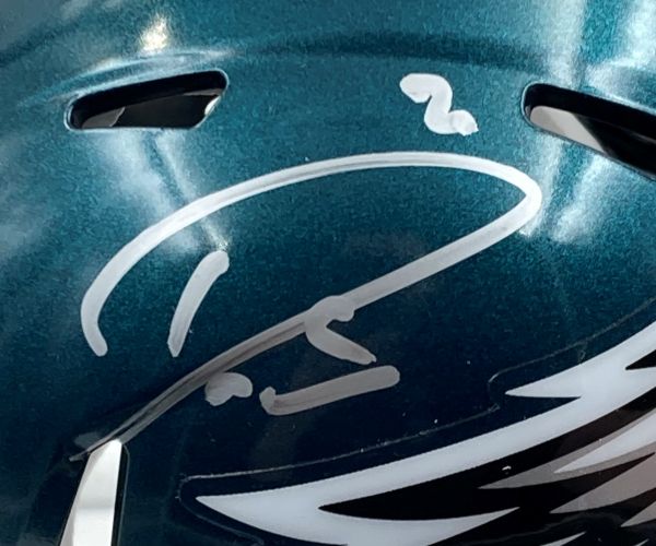 A close-up of the Sports Integrity Darius Slay Signed Philadelphia Eagles Mini Helmet, featuring his signature and the number 2 above it. Part of the Eagles logo is visible near the bottom, and it comes with a Super Bowl 59 LIX case.