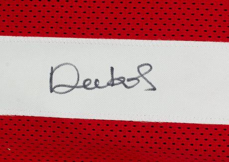 A close-up of a Deebo Samuel Signed Custom Red Pro Style Football Jersey by Sports Integrity, featuring a white stripe with a black autograph across it.