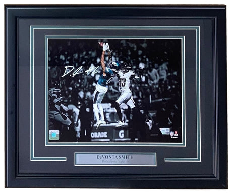 The Sports Integrity Devonta Smith Signed Framed 11x14 Philadelphia Eagles Photo features his autograph and a nameplate, capturing him making a leaping catch. Available from Fanatics.