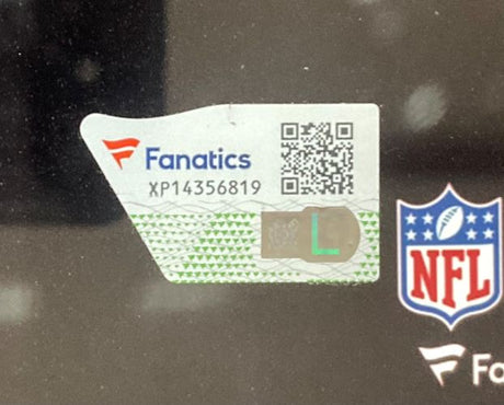 A close-up of a Fanatics authenticity sticker with code XP14356819, a QR code, and an L hologram beside an NFL logo on the Sports Integrity Devonta Smith Signed Framed 11x14 Philadelphia Eagles Photo. The sticker features green and gray patterns.