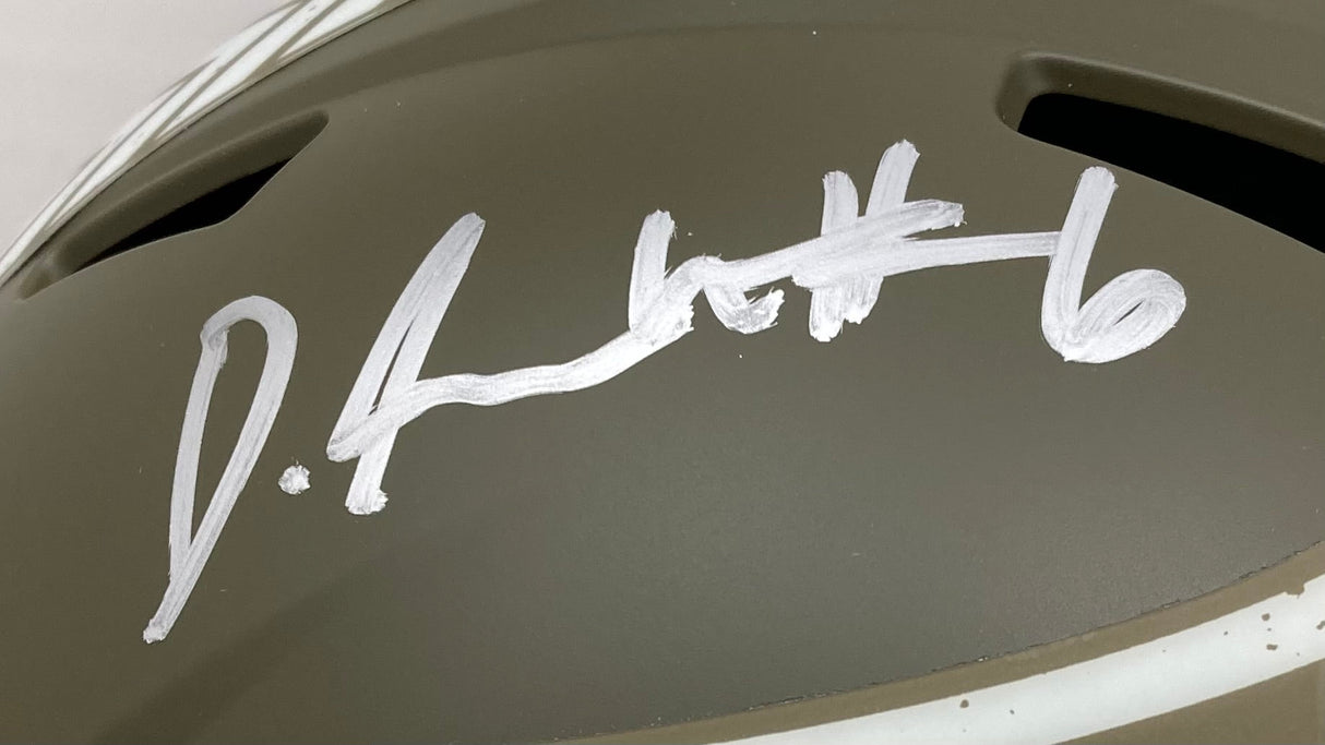 A Devonta Smith Signed Eagles FS Salute To Service Speed Replica Helmet by Sports Integrity is shown close-up, displaying a bold silver autograph with the number 6 on the green surface; some helmet and background details are visible.