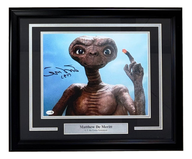 Sports Integrity’s Matthew De Merritt Signed Framed 11x14 ET Photo (JSA) features E.T. with a glowing finger and includes a plaque reading “Matthew De Merritt, E.T. the Extra-Terrestrial.”.