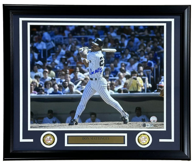 The Sports Integrity Don Mattingly Signed Framed 16x20 New York Yankees Photo BAS features Mattingly in a pinstripe uniform swinging a bat, signed in blue ink, with two gold medallions and a nameplate. Stadium crowd background.