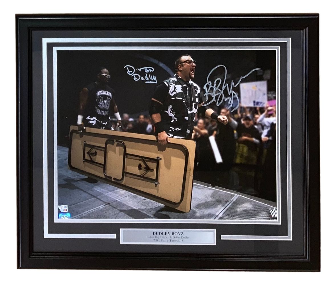 The Dudley Boyz Signed Framed 16x20 WWE Photo by Sports Integrity features both wrestlers in black outfits, walking down a wrestling ramp with a wooden table, autographed and perfect for any fan's collection.