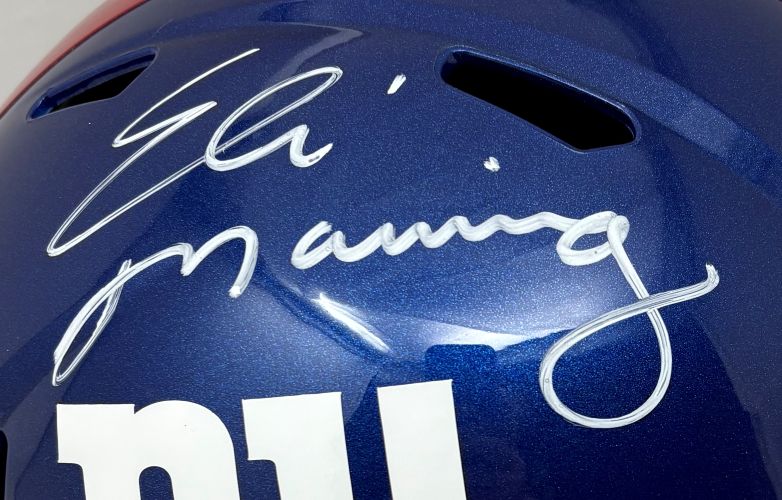 Close-up of an Eli Manning Signed New York Giants Full Size Speed Replica Helmet by Sports Integrity, featuring his white autograph above the partially visible white NY logo.