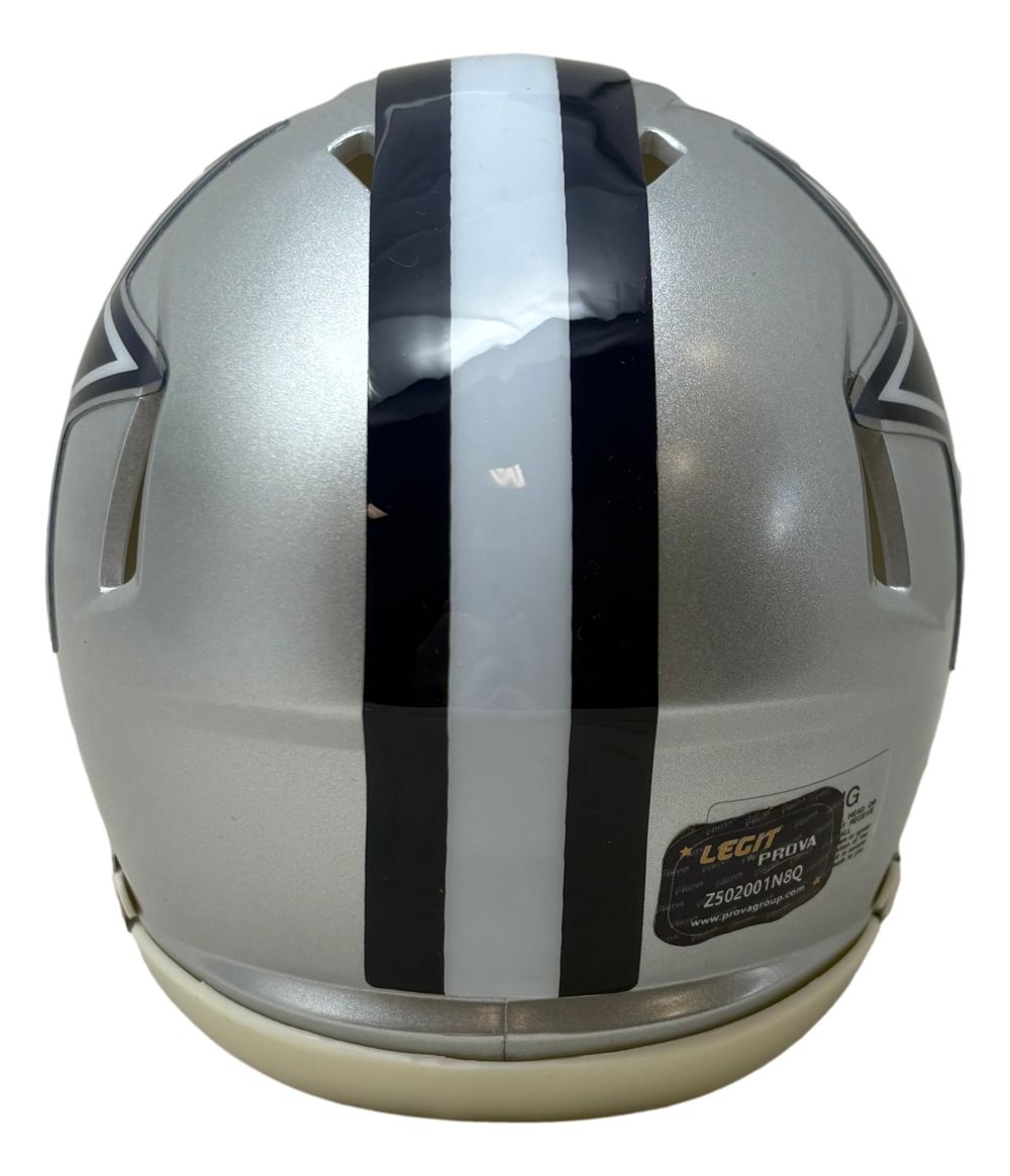 The Emmitt Smith Signed Dallas Cowboys Mini Speed Helmet by Sports Integrity features a silver finish, central dark blue and white stripe, navy star logo edges on both sides, a small sticker label near the base, and comes with a Prova Hologram and case.