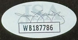 Oval sticker with faded text and signatures, showcasing "WB187786" in a bold, bordered rectangle; from Sports Integrity’s Entourage Cast Signed Framed 16x20 Photo (Grenier & others, JSA ITP).