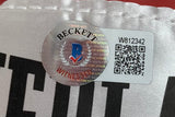 Close-up of a Beckett Witnessed Authentication sticker on a Floyd Mayweather Jr Signed Red Everlast Right Hand Boxing Glove by Sports Integrity, showing the holographic seal, blue and red logo, "WITNESSED," QR code, and ID “W812342.”.