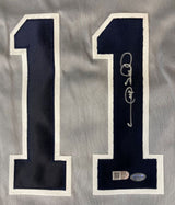 A close-up of the number 11 in dark blue with white trim on gray fabric from the Gary Sheffield New York Signed Gray Baseball Jersey by Sports Integrity, showing a silver autograph and two authentication stickers on the lower right digit.