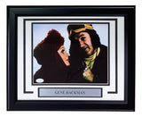 Sports Integrity's Gene Hackman Signed Framed 8x10 Superman II Photo features two costumed characters, one in a red hood and one in a yellow and brown headpiece. Includes a plaque with Gene Hackman's name. Authenticated by JSA.