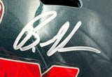 A close-up of the Brandon Graham Signed Eagles FS Super Bowl 59 LIX Replica Helmet by Sports Integrity shows a large silver autograph on its glossy, dark green surface, with part of a red and white sticker at the bottom.