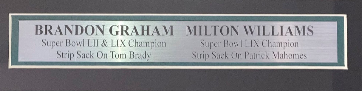 The Sports Integrity Graham Williams Signed Framed 16x20 Eagles Super Bowl Strip Sack Photo BAS features highlights of Brandon Graham’s iconic strip sack on Tom Brady and Milton Williams’ strip sack on Patrick Mahomes.