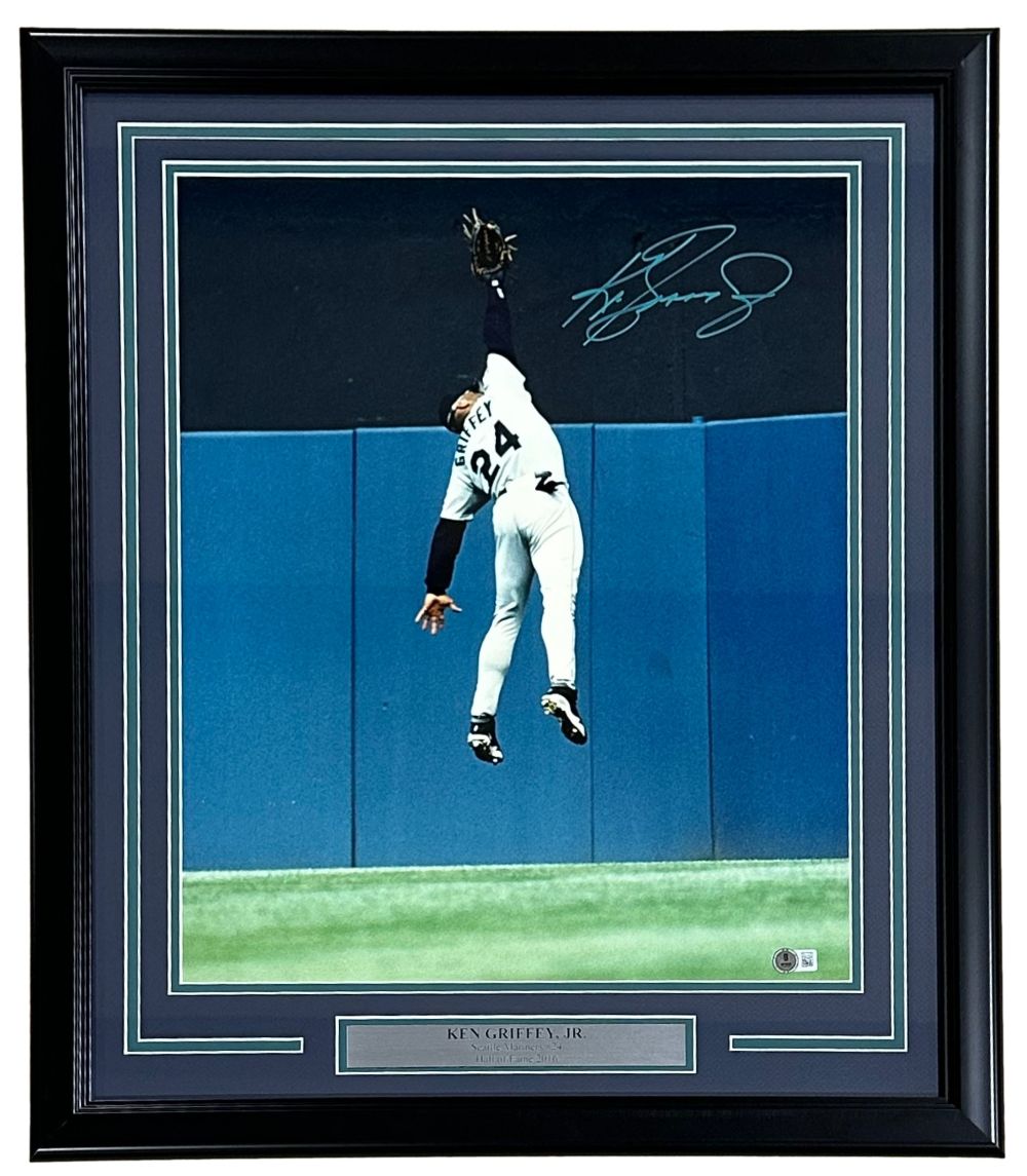 The Sports Integrity Ken Griffey Jr. Signed Framed 16x20 Seattle Mariners Wall Catch Photo features his autograph and a silver plaque, showcasing Griffey leaping at the outfield wall in his “Griffey 24” jersey. BAS ITP authenticated.