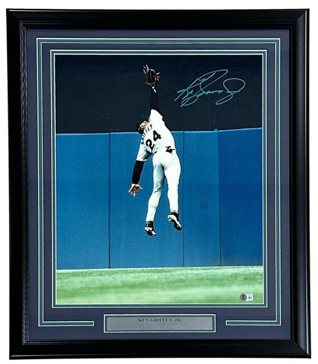 The Sports Integrity Ken Griffey Jr. Signed Framed 16x20 Seattle Mariners Wall Catch Photo features his autograph and a silver plaque, showcasing Griffey leaping at the outfield wall in his “Griffey 24” jersey. BAS ITP authenticated.
