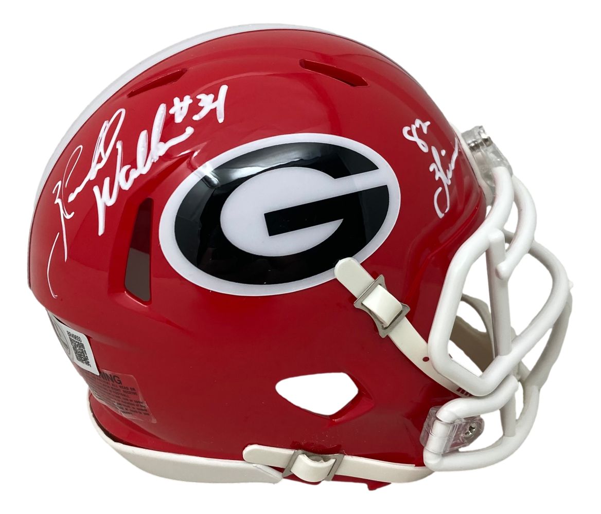 The Sports Integrity Herschel Walker Signed Georgia Bulldogs Mini Speed Helmet features a red shell with a black and white "G" logo, white faceguard, and autographs above and beside the logo. 82 Heisman/BAS authenticated.