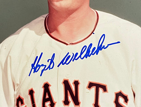 A close-up of Hoyt Wilhelm in a cream New York Giants jersey, with his autograph in blue ink across the chest. Product: Hoyt Wilhelm Signed 8x10 New York Giants Baseball Photo BAS by Sports Integrity. Player's face is partially out of frame.