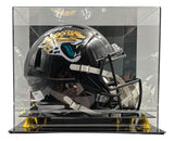 The Travis Hunter Signed Jacksonville Jaguars FS Speed Replica Helmet by Sports Integrity is showcased in a clear acrylic case with a black and gold base.