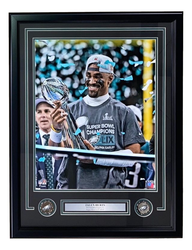 A Philadelphia Eagles player beams in a Sports Integrity Jalen Hurts Framed 16x20 Super Bowl 59 Trophy Photo, holding the Lombardi Trophy amid blue confetti, with coins and a nameplate.