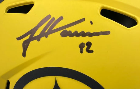 A close-up of a James Harrison signed Steelers FS Rave Speed Replica Helmet by Sports Integrity, showing the black signature and number 32 in marker above a black circular design, comes with a case.