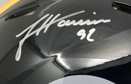 Close-up of a Sports Integrity Pittsburgh Steelers Authentic Speed Helmet, full size and black, autographed by James Harrison with "92" in silver marker. Features air vents and reflective surfaces. BAS authenticated.