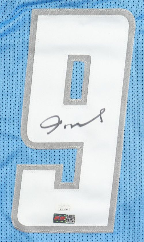 A Jameson Williams Detroit light blue football jersey by Sports Integrity features a large white number 9 with black autograph, JSA hologram, and two authentication stickers at the bottom.