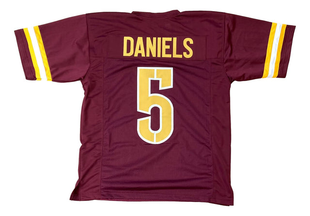 The Sports Integrity Jayden Daniels Washington Burgundy Football Jersey features yellow and white sleeve stripes, with "DANIELS" and the number 5 in bold yellow on the back.