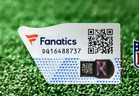 A Sports Integrity Jaylen Waddle Signed Framed 8x10 Miami Dolphins Photo features a Fanatics authentication sticker with QR code, serial DQ16488737, holographic security, and partial NFL logo on a green grass background.