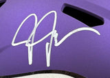 A white autograph is inscribed on the smooth, purple surface of a Justin Jefferson Signed Minnesota Vikings FS Replica Speed Helmet by Sports Integrity, with black vent openings visible above the signature.