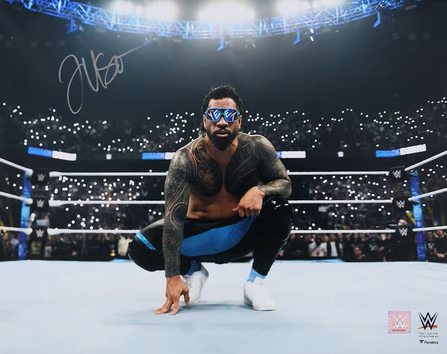 The Sports Integrity Jey Uso Signed 16x20 WWE Kneeling Photo shows Jey Uso in the ring, surrounded by cheering fans with lit phones in a bright arena—a must-have for WWE collectors.