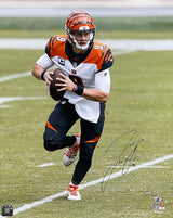 The Sports Integrity Joe Burrow Signed 16x20 Cincinnati Bengals Football Photo features Joe Burrow in a Bengals uniform and number 9 jersey, running with the ball. The autograph appears on the lower right. Authenticated by Fanatics.