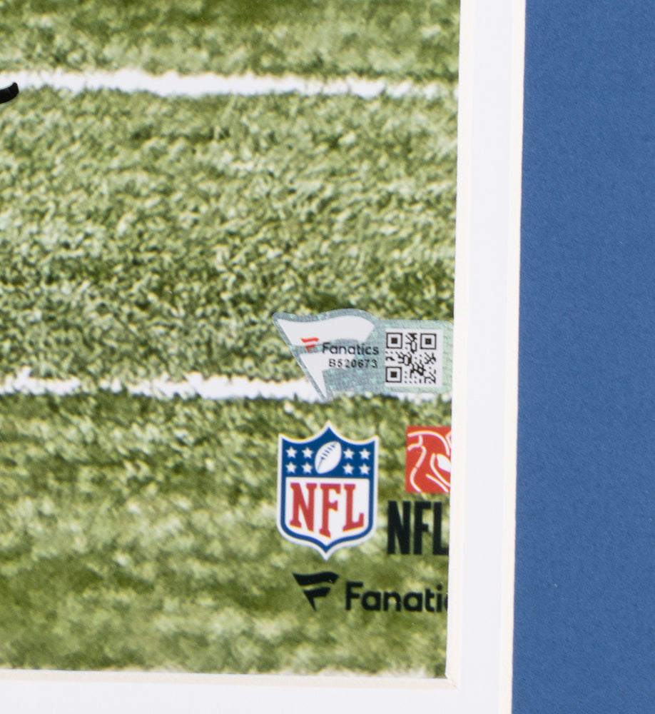Close-up of the corner of a Sports Integrity Jonathan Taylor Signed Framed 16x20 Indianapolis Colts Photo, featuring part of a football field, plus NFL and Fanatics logos and a QR code—showcasing the Colts theme.