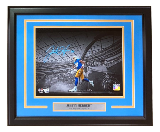 Sports Integrity Justin Herbert Signed Framed 11x14 Los Angeles Chargers Photo by Fanatics, featuring #10 in blue and yellow uniform running on the field with a stadium backdrop.