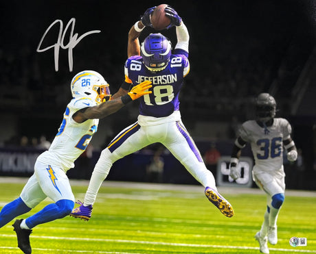 A Justin Jefferson Signed 16x20 Minnesota Vikings Photo vs Chargers by Sports Integrity shows Jefferson in a purple jersey leaping for a catch, defended by a player in white, with another in gray watching; autograph on top left.
