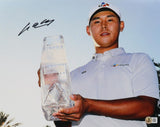 Si Woo Kim, in a white shirt and cap, holds a clear trophy in this signed 11x14 PGA Golf Photo by Sports Integrity. His signature appears in the top left. Palm trees and a blue sky enhance the background.
