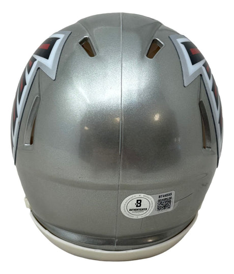 The Kyle Pitts Signed Atlanta Falcons Flash Mini Speed Helmet by Sports Integrity is silver with black and red angular designs, viewed from the back, and features a round BAS authentication sticker with a QR code near the bottom.