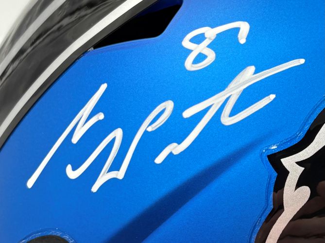 A close-up of the Sam LaPorta Signed Lions FS Alternate Blue Speed Replica Helmet by Sports Integrity, showcasing a bold white autograph and part of the black and silver logo on the right edge.