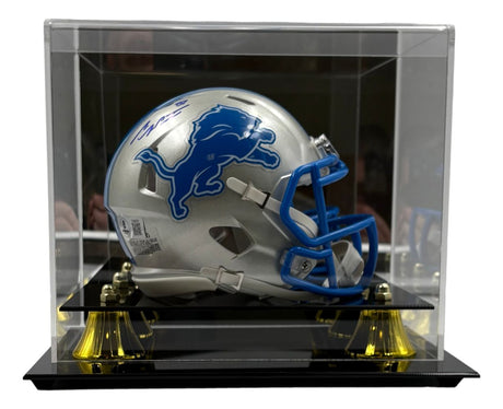 The Sports Integrity Sam LaPorta Signed Detroit Lions Mini Speed Helmet features a blue lion logo and faceguard, autographed in blue ink, and comes in a clear acrylic display case with gold accents.
