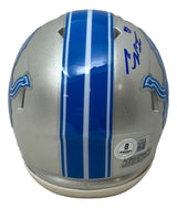 The Sports Integrity Sam LaPorta Signed Detroit Lions Mini Speed Helmet features blue stripes, the team logo, an autograph in blue ink, and an authenticity sticker on the back. Includes BAS certification and a display case.