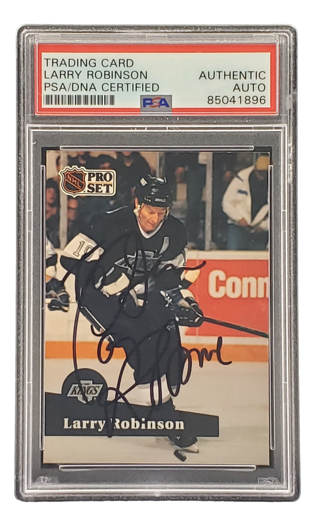 The Sports Integrity Larry Robinson Signed 1991 Pro Set #104 LA Kings Hockey Card (PSA/DNA 85041896) features Robinson with a hockey stick on the ice, encased in a PSA/DNA certified holder labeled "Authentic Auto.