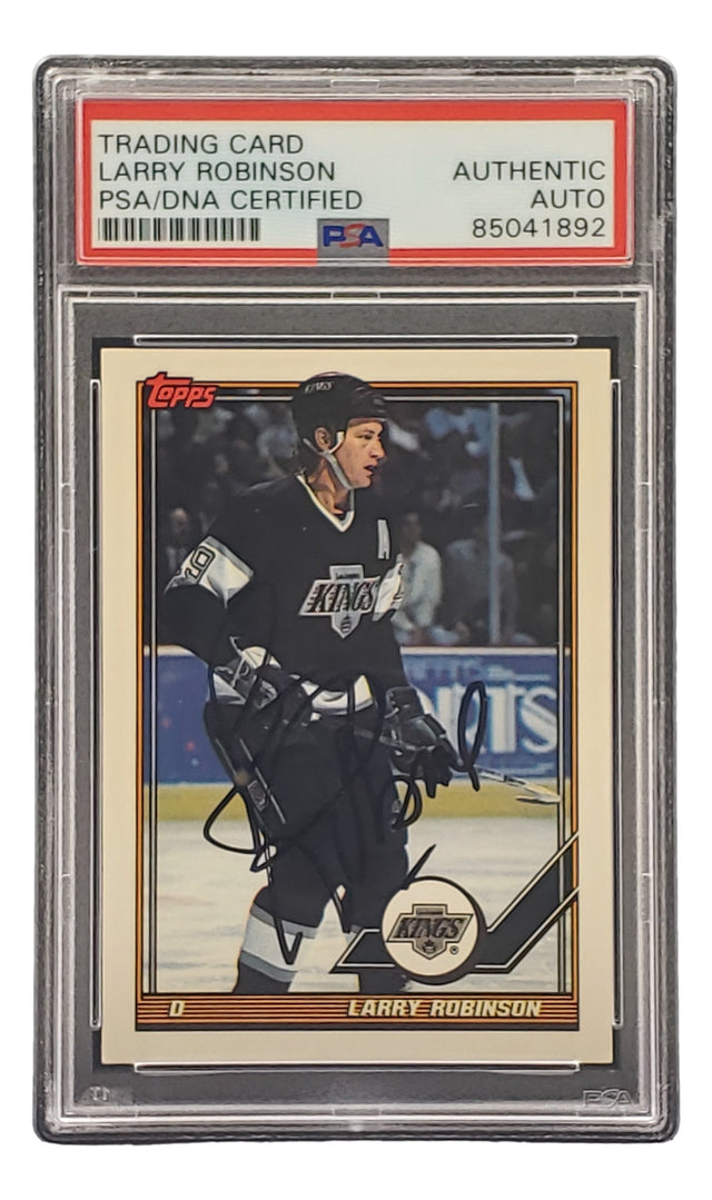 The Sports Integrity Larry Robinson Signed 1991 Topps #458 Los Angeles Kings hockey card is PSA/DNA authenticated, autographed, shows the Topps logo, and comes encased in a protective plastic holder.