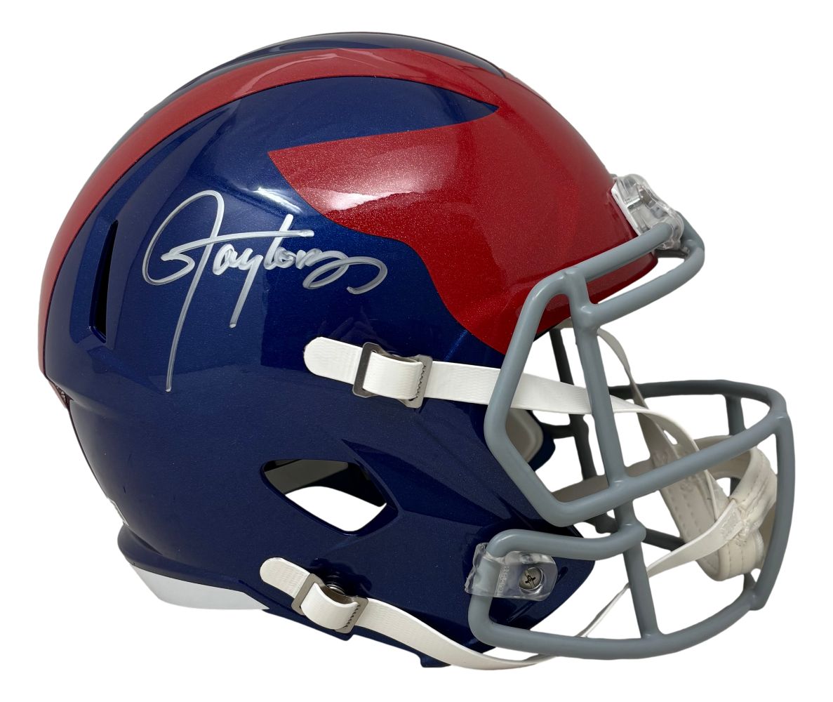 The Sports Integrity Lawrence Taylor Signed New York Giants FS Alternate Speed Replica Helmet BAS features a blue shell, red top design, gray face mask, and a bold white autograph on the side.