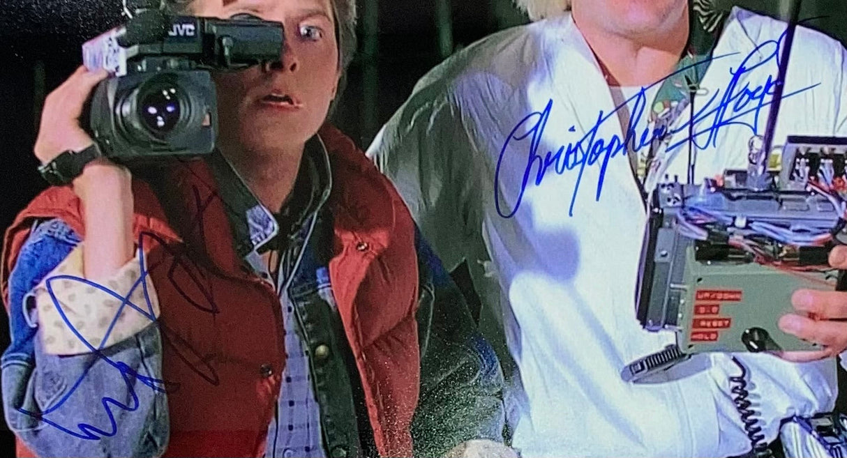 Michael J. Fox and Christopher Lloyd are seen in a framed 16x20 "Back to the Future" camera photo, both with large blue autographs, signed and authenticated by BASJSA. Offered by Sports Integrity.