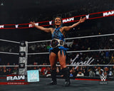 A smiling Lyra Valkyria stands center ring in WWE gear, arms outstretched with a championship belt, as spectators cheer. This signed 8x10 WWE photo is available from Sports Integrity via Fanatics.