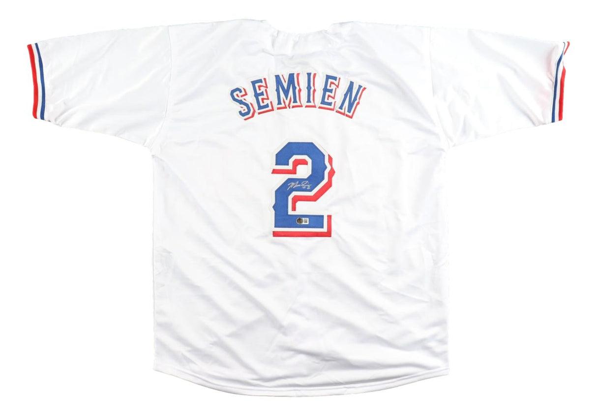 The Sports Integrity Marcus Semien Texas Signed White Baseball Jersey BAS features blue and red trim, SEMIEN in blue across the back, the number 2 below outlined in red and blue, and a signature on the number.