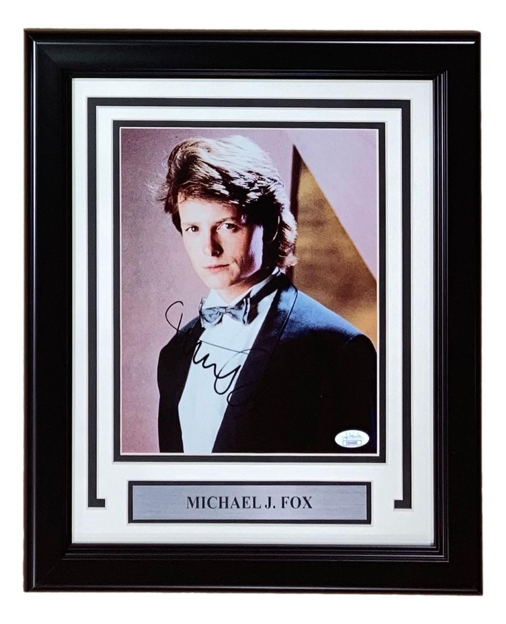The Sports Integrity Michael J Fox Signed Framed 8x10 Photo (JSA) features his autograph and includes a nameplate reading “Michael J. Fox.”.
