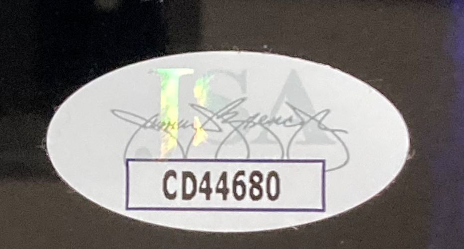 Sports Integrity’s Michael J Fox Signed Framed 8x10 Photo features a signature, an oval sticker with faint JSA text, and a bold black box at the bottom with code CD44680.