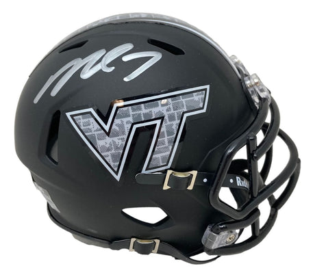 The Sports Integrity Michael Vick Signed Virginia Tech Hokies Matte Black Mini Speed Helmet features a silver VT logo with a patterned design, black facemask and buckles, plus a large silver Michael Vick signature on top.