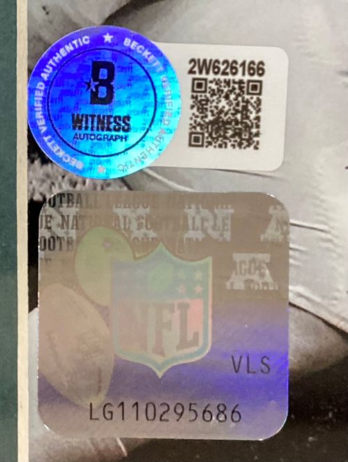 Close-up of authentication stickers on the Milton Williams Signed Framed 8x10 Eagles SB 59 Mahomes Strip Sack Photo by Sports Integrity: a blue Beckett Witness Autograph sticker with QR code and a silver NFL sticker with code LG110295686.