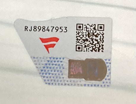 A Sports Integrity security sticker for the Nia Jax Signed Framed 8x10 WWE Photo Fanatics features code RJ89847953, a red stylized F logo, QR code, holographic section, and blue triangles on a white background.
